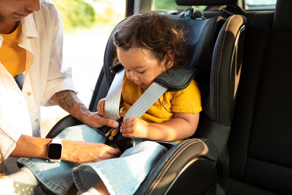 Asian,Mom,Sitting,Down,Her,Toddler,Daughter,In,Baby,Car